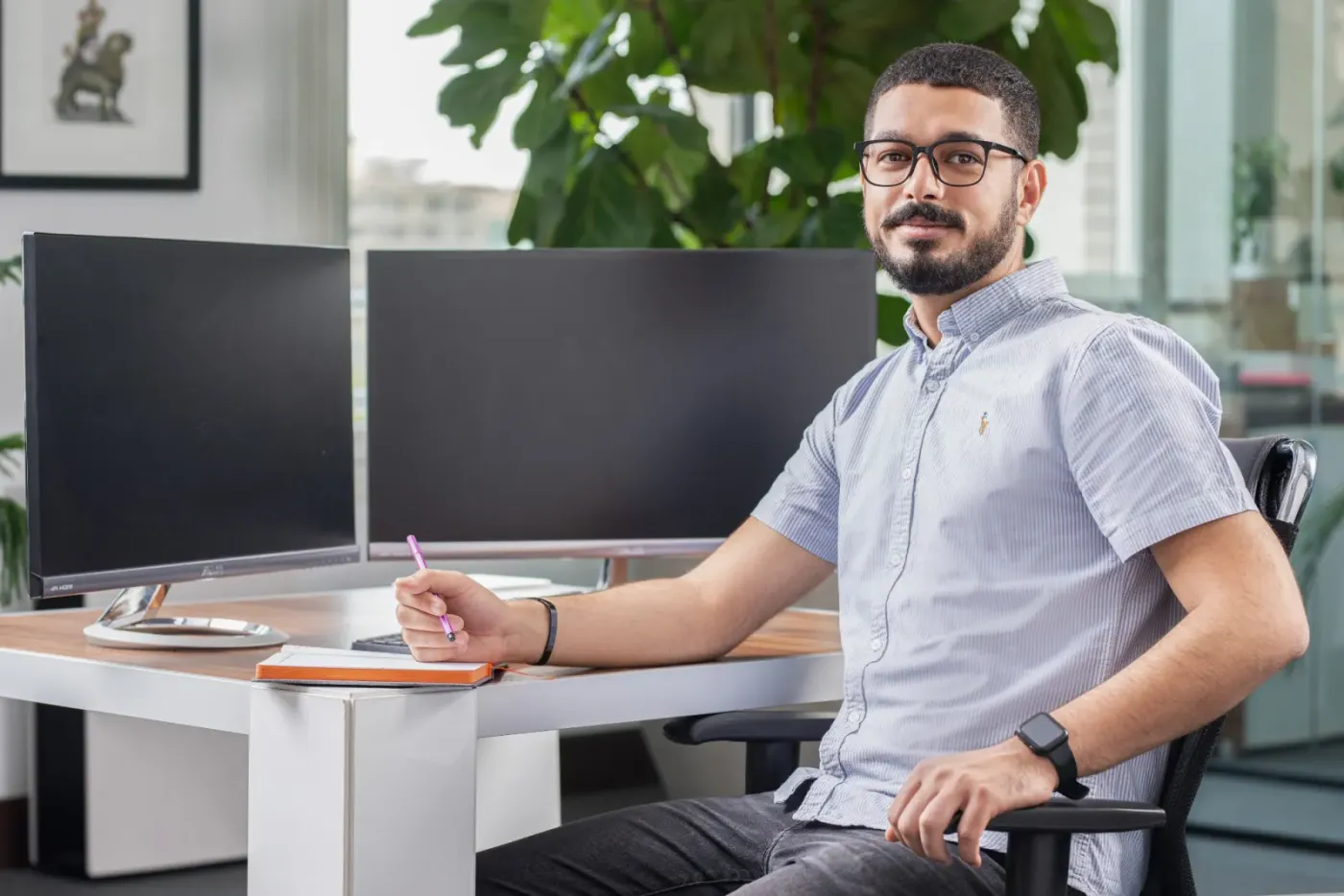 همکاری پشت میز کارش با دو مانیتور