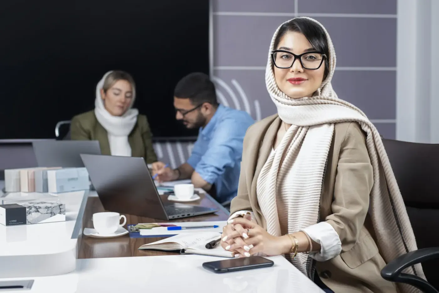 همکاری با عینک پشت میز جلسه، رو به دوربین