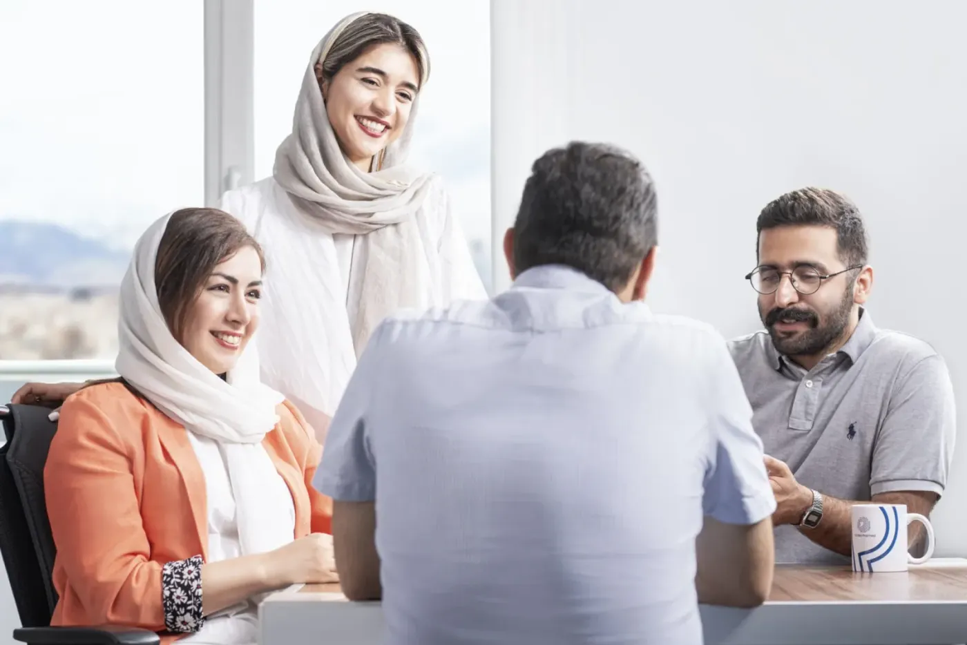 گفت‌وگوی دوستانه‌ی چهار همکار دور یک میز